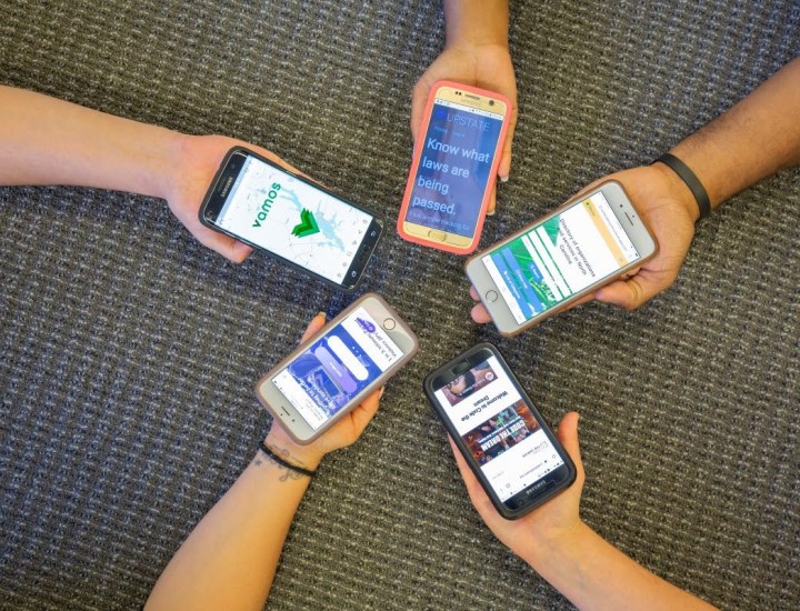Five people hold their phones together