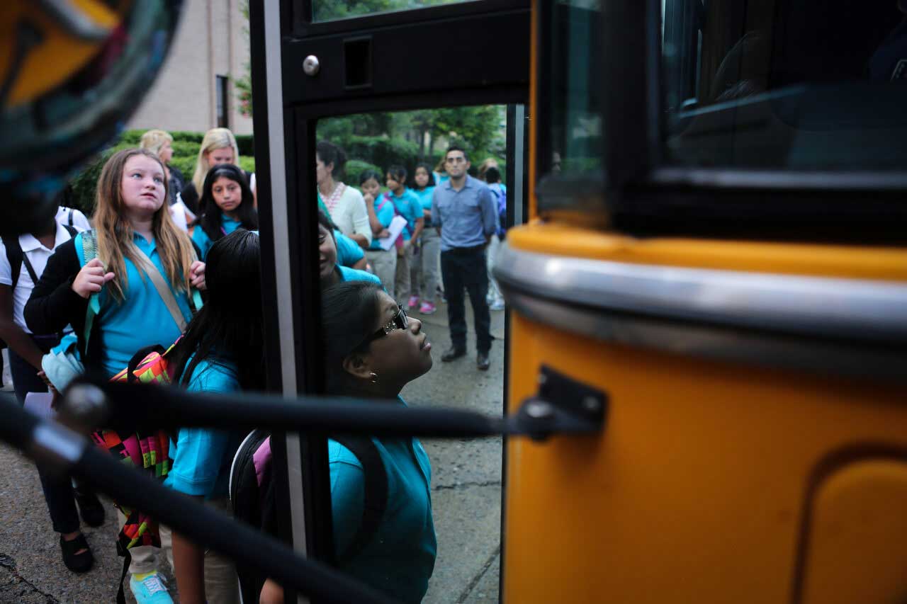 Students board a school bus