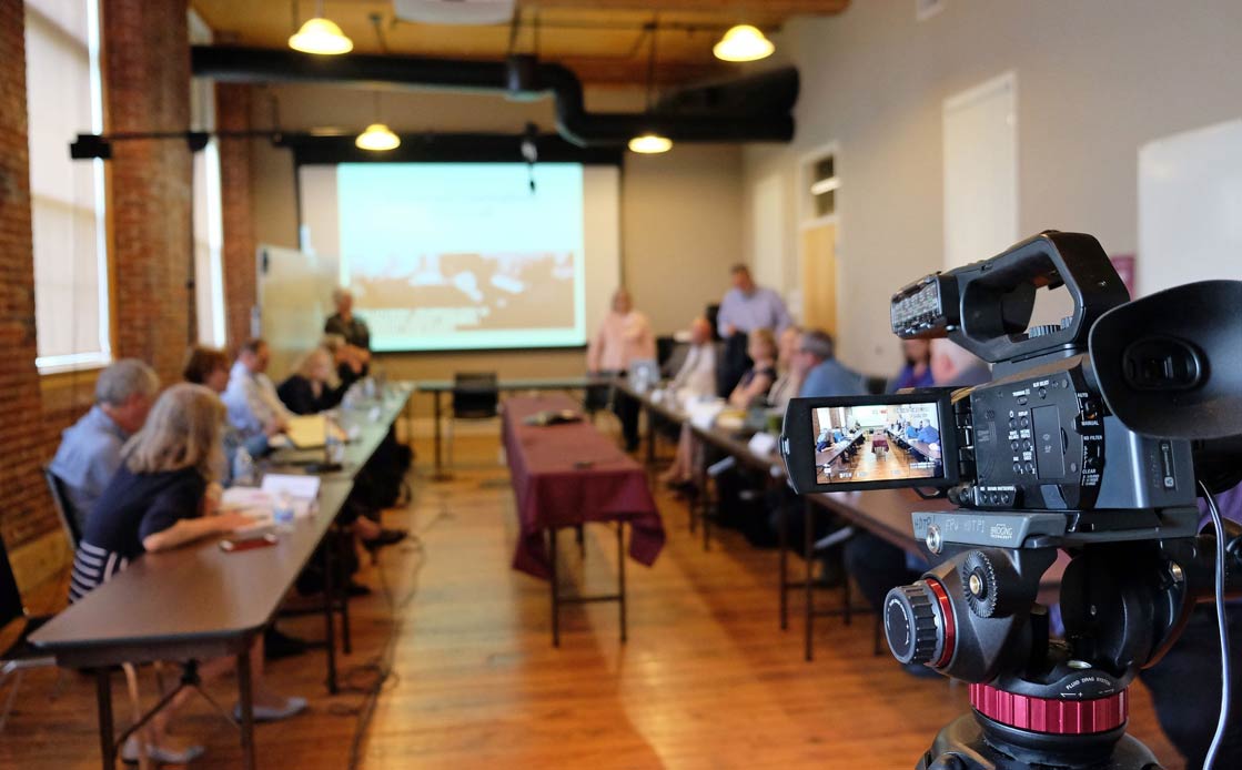 A video camera pointed at a meeting of people