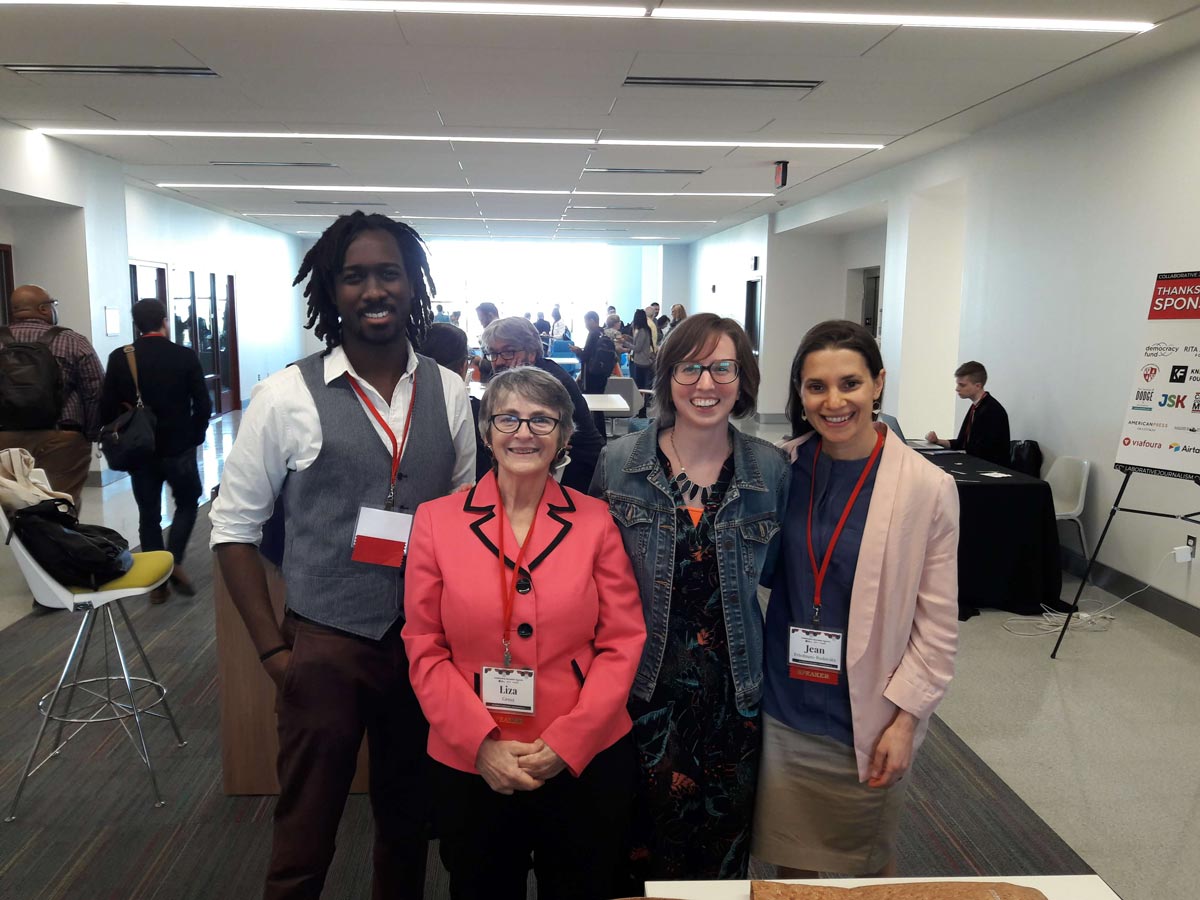 Four people posing together at a conference