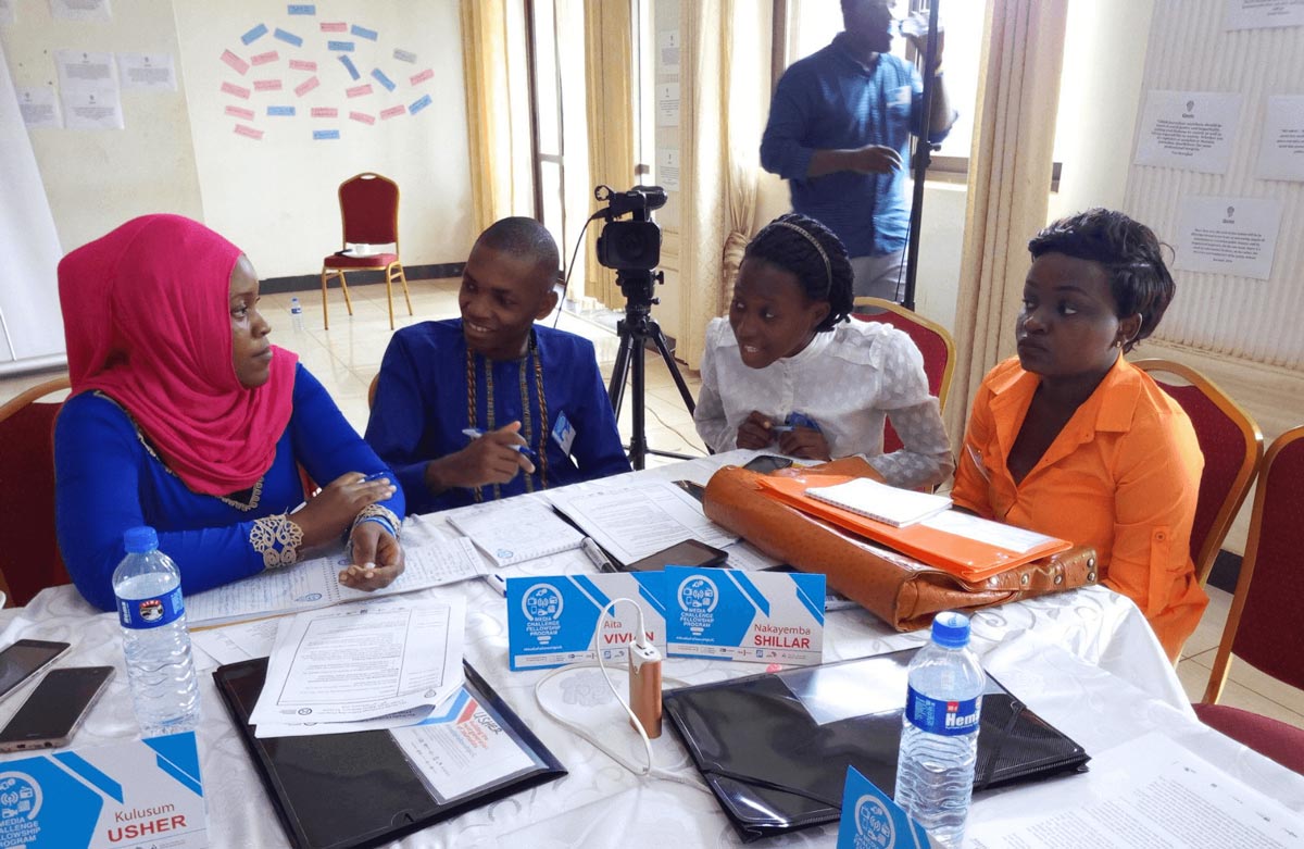 Four Black people sitting around a table covered in papers