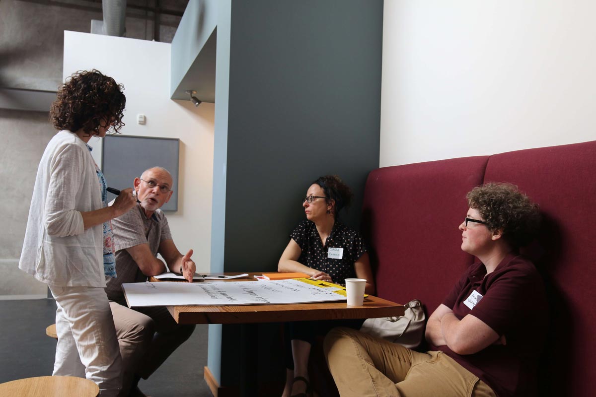 Four people talking at a square table