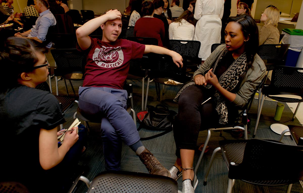 Three people sitting in a smaller group discussion in a meeting