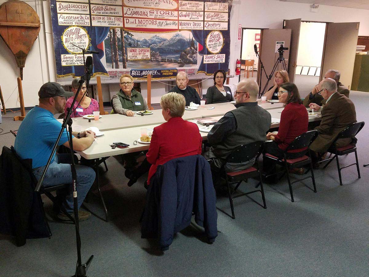 11 people sitting around a long rectangular table