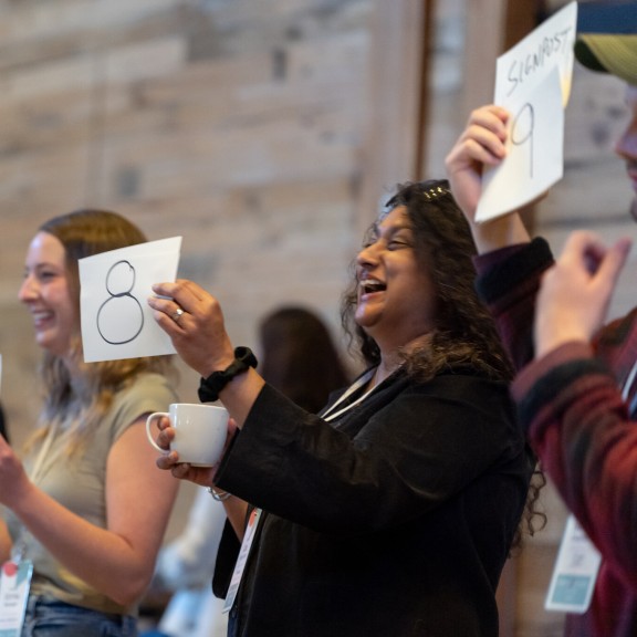 People hold up cards at an SJN Summit