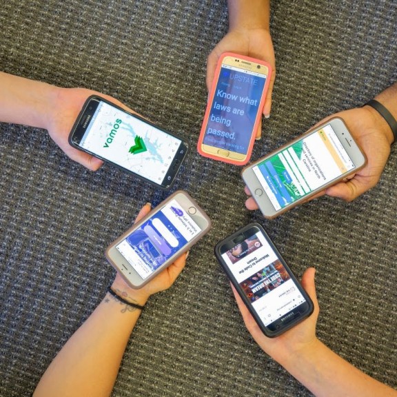 Five people hold their phones together