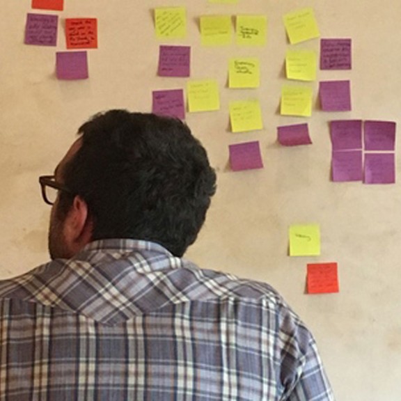 person looking at post-it notes on a wall