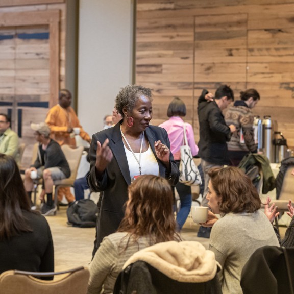 Participants in the 2022 SJN Summit speak with each other in a conference room