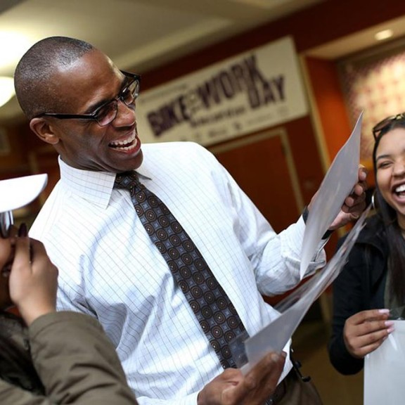 teacher and three students laughing together