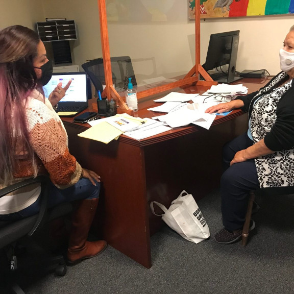 Health educator Ana Hernandez works with Maria Esther Jimenez, a client, at the Fruitvale – San Antonio Senior Center in Oakland. Hernandez, who works for La Clínica, frequently stops at the senior center to help people enroll in Medi-Cal, the state’s Medicaid program. Credit: Claudia Boyd-Barrett / El Timpano.