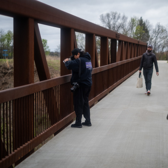 A journalist takes a photo from a bridge