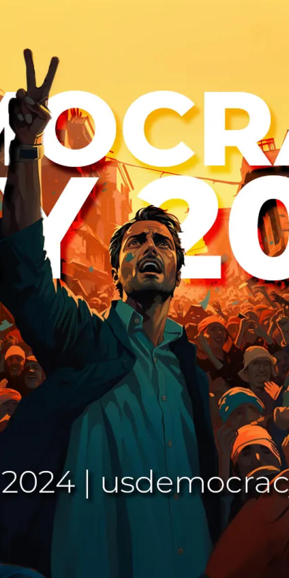 A man holds up his hand in a crowd scene