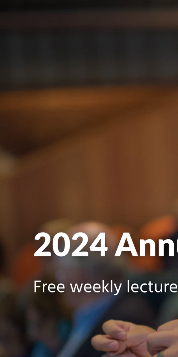 A man smiles with a pencil behind his ear