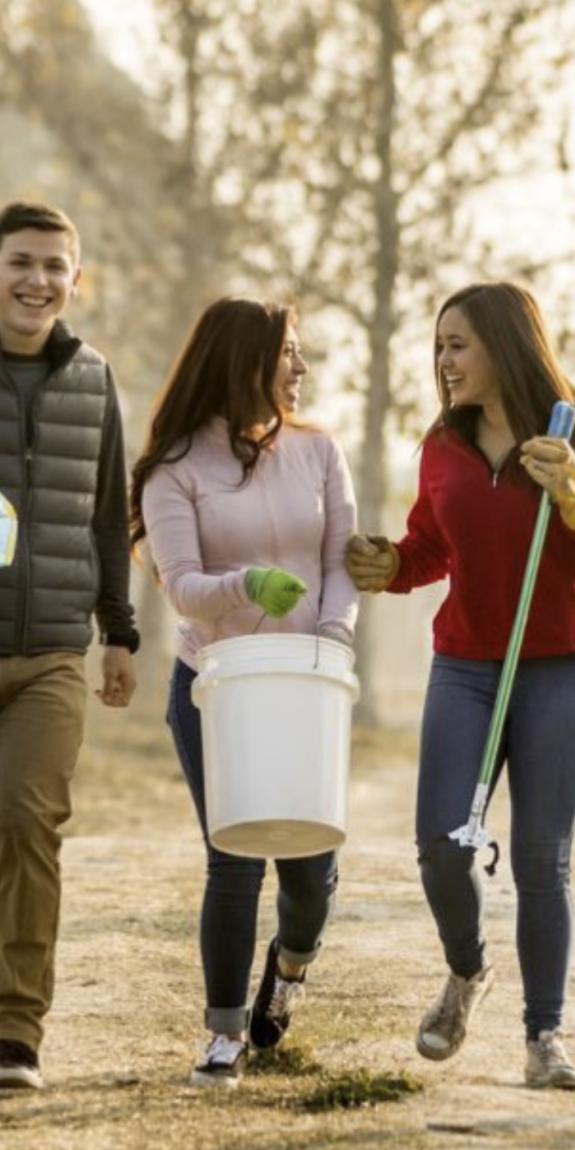 Young adults pick up trash in a park