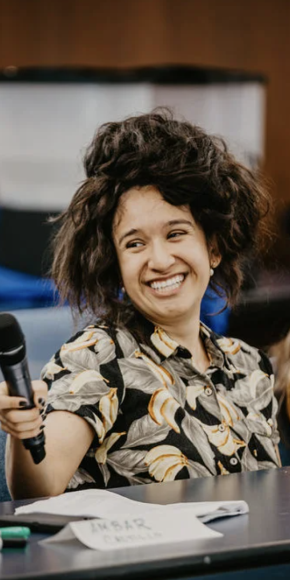 A woman with a microphone smiles