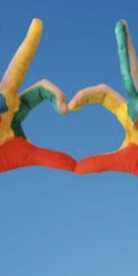 A person makes a heart with their hands, which are painted with bright colors