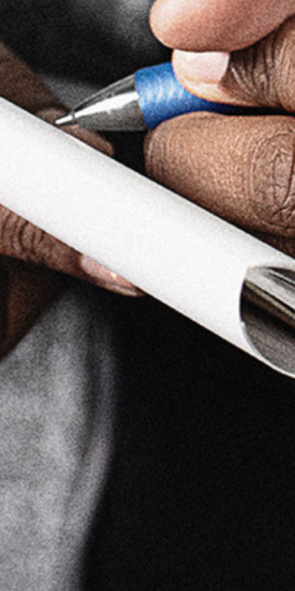 A reporter holds a microphone and takes notes