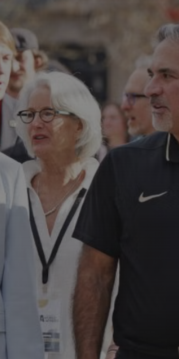People talk while walking through a path lined with flags
