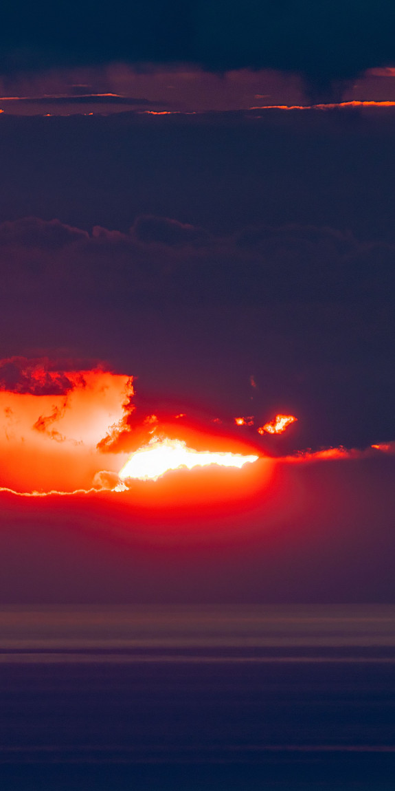 The sun shines from behind clouds