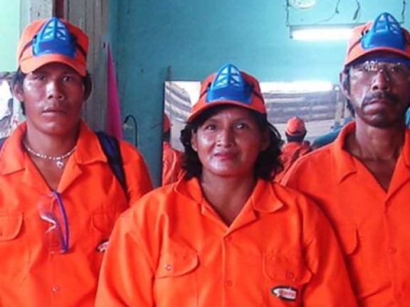 Three people pose in orange coverall suits