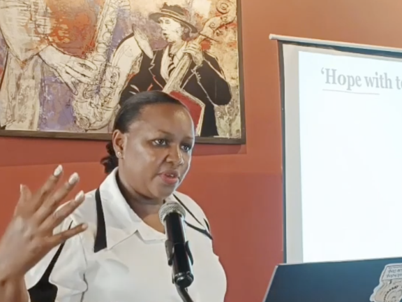 Caroline Karobia speaks at a podium during the "Media Science Cafe" event