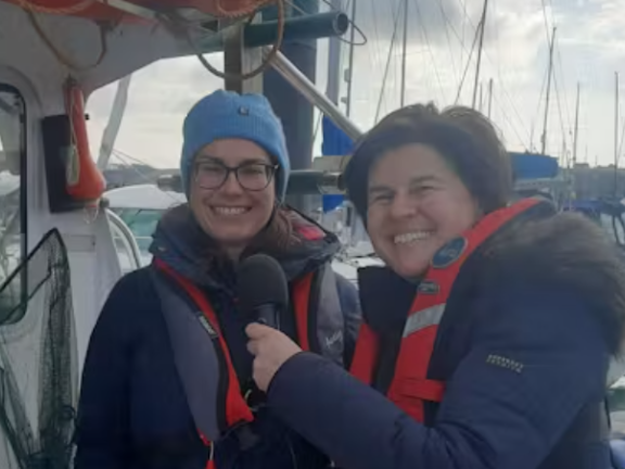 Anna Turns conducts an interview on a boat