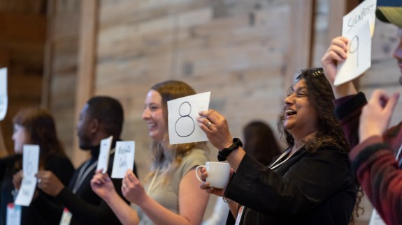 People hold up cards at an SJN Summit