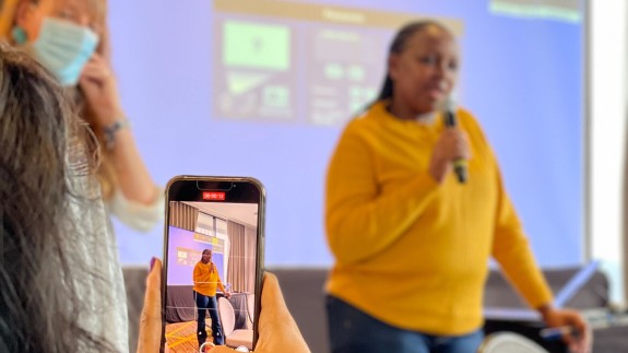 A person takes a photo of Africa Initiative manager Caroline