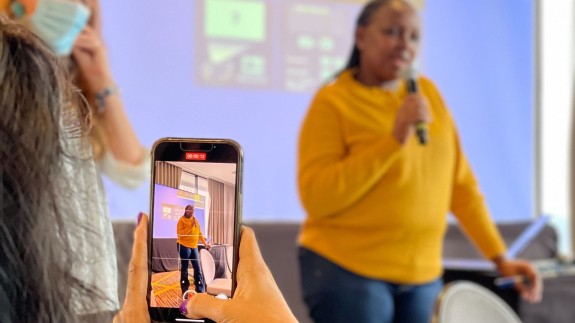 Ambika takes a photo of Caroline presenting at an SJN retreat