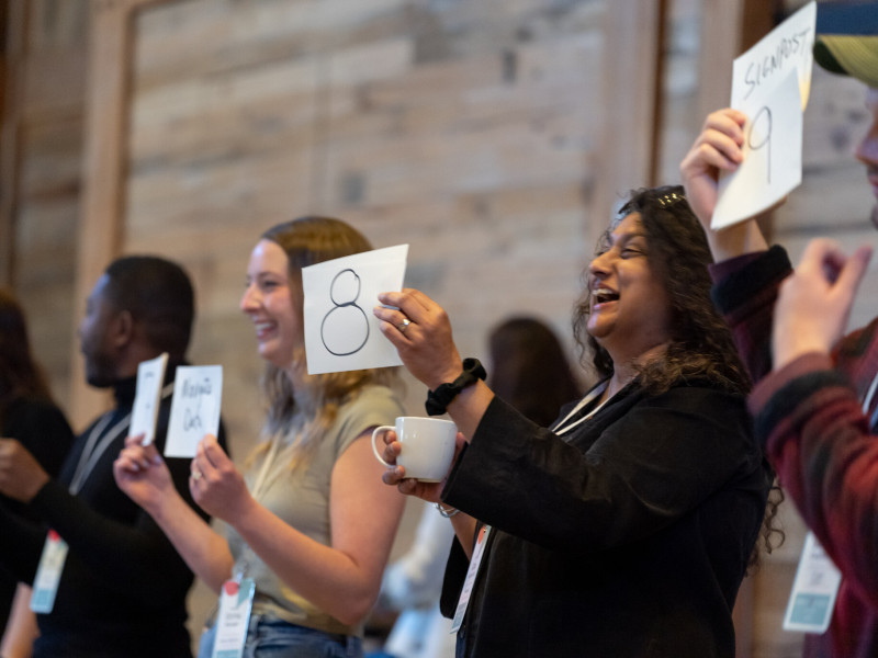 People hold up cards at an SJN Summit