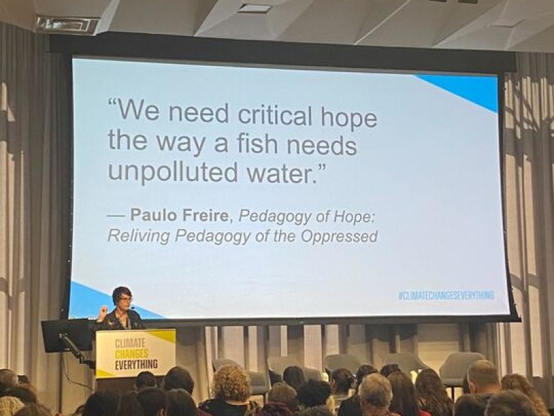 A quote is shown on a presentation slide, "We need critical hope the way a fish needs unpolluted water" by Paulo Freire 
