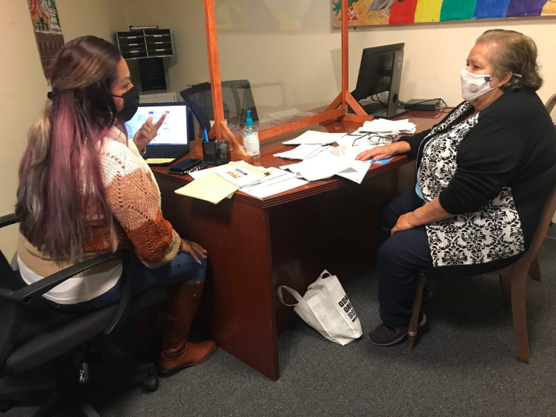 Health educator Ana Hernandez works with Maria Esther Jimenez, a client, at the Fruitvale – San Antonio Senior Center in Oakland. Hernandez, who works for La Clínica, frequently stops at the senior center to help people enroll in Medi-Cal, the state’s Medicaid program. Credit: Claudia Boyd-Barrett / El Timpano.