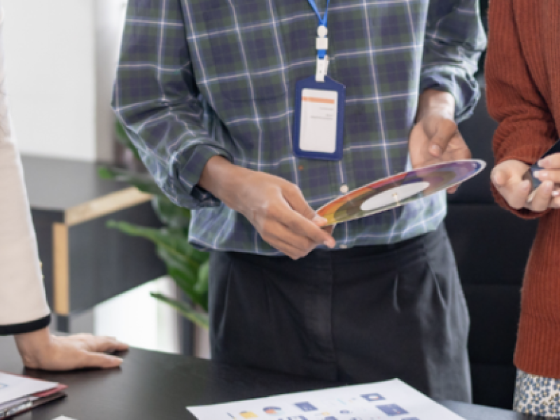 People stand at a table reviewing notes