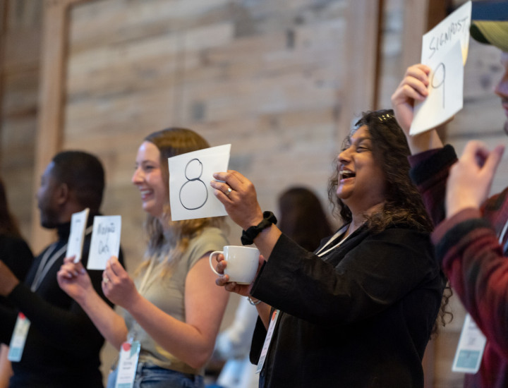 People hold up cards at an SJN Summit