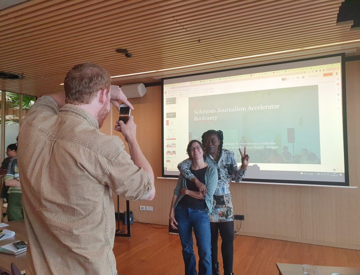EJC event participants pose - one takes a photo of two people hugging and showing a peace sign