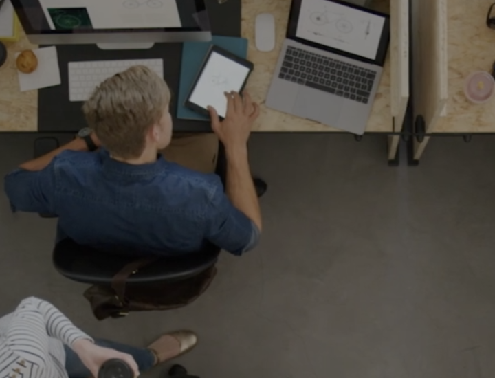 Aerial view of two people working on computers and tablets