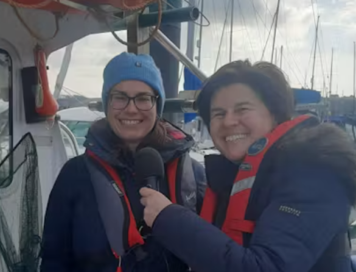 Anna Turns conducts an interview on a boat
