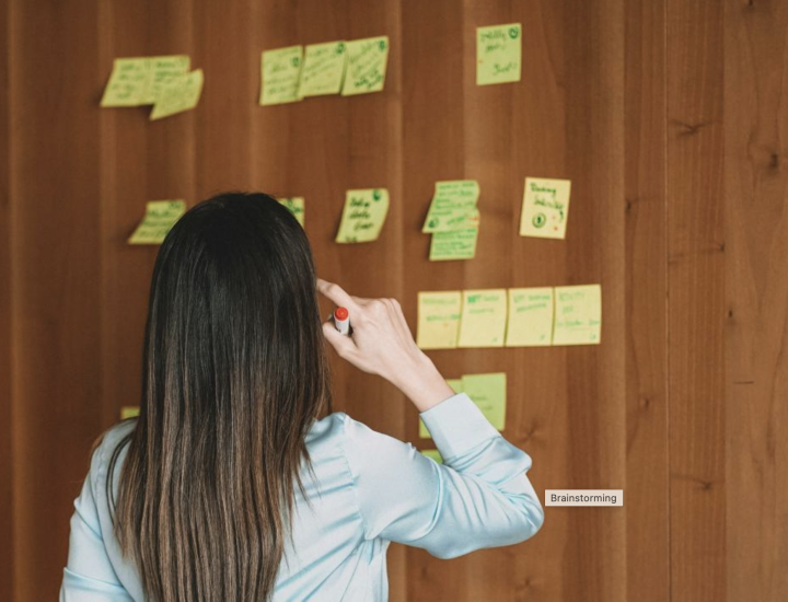 A woman looks at sticky notes on the wall