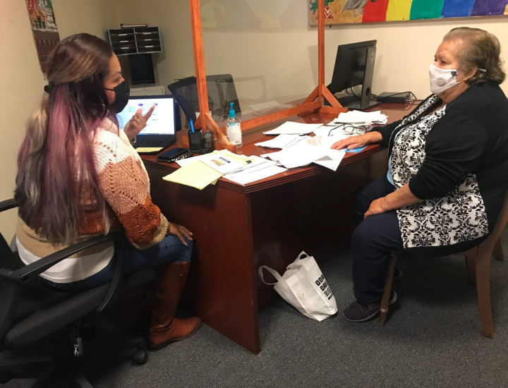 Health educator Ana Hernandez works with Maria Esther Jimenez, a client, at the Fruitvale – San Antonio Senior Center in Oakland. Hernandez, who works for La Clínica, frequently stops at the senior center to help people enroll in Medi-Cal, the state’s Medicaid program. Credit: Claudia Boyd-Barrett / El Timpano.