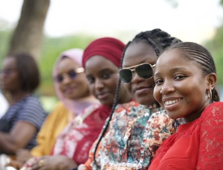 4 women in a row smiling at the camera
