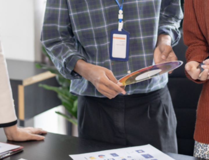People stand at a table reviewing notes