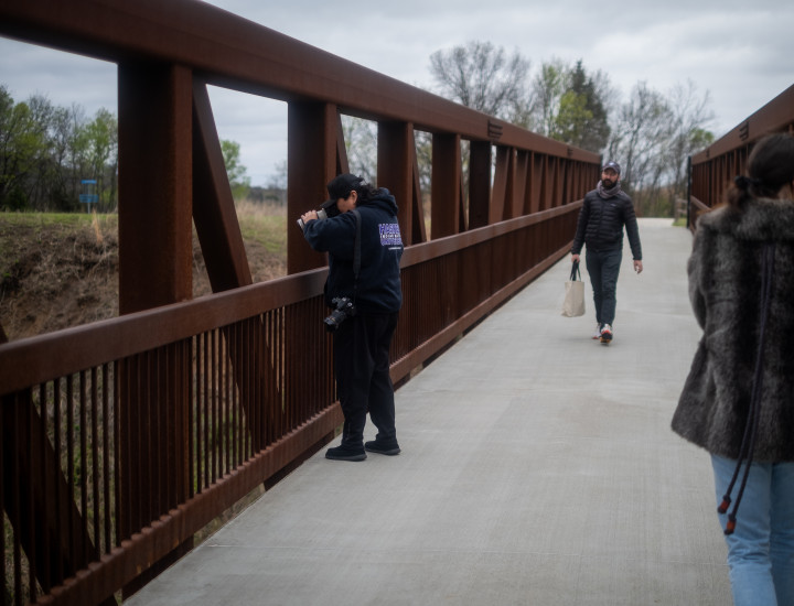 A journalist takes a photo from a bridge